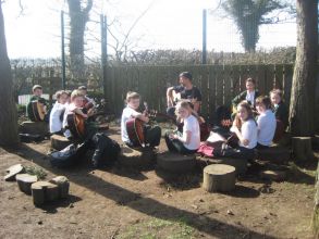 Children enjoying music lessons in the sunshine!